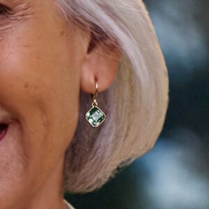 Aretes Capri Doré Yanbal puestos en la oreja con cristales verdes